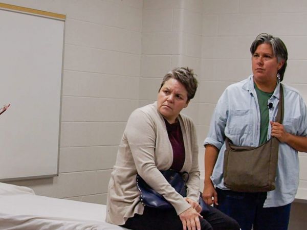 Four people acting as patients and health-care workers perform a scene from a play.