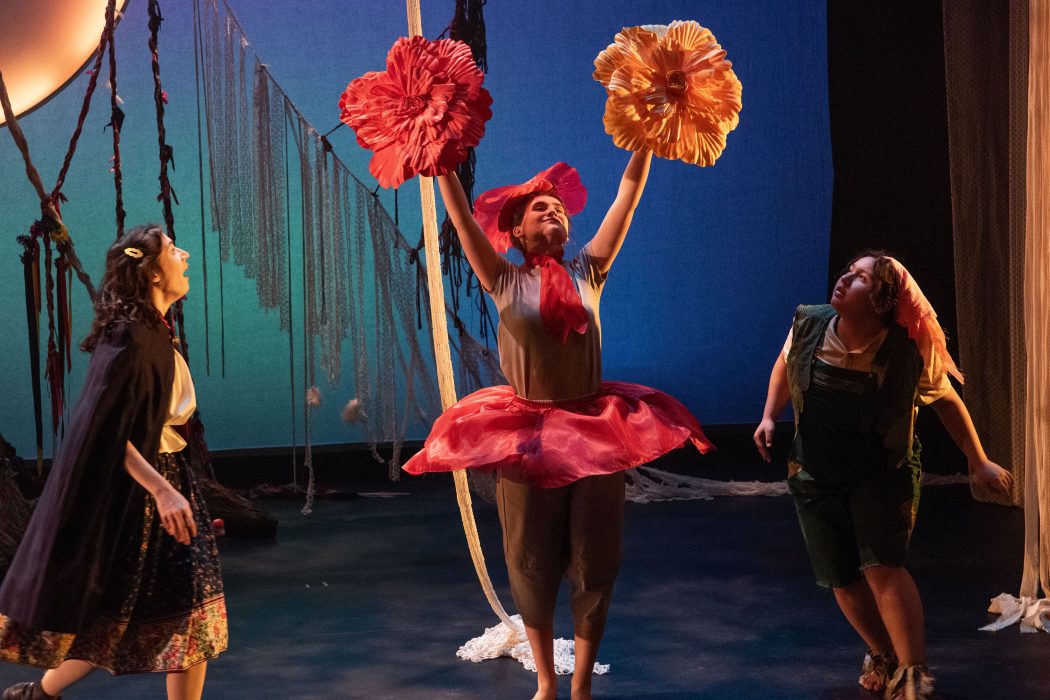 Actors perform on stage wearing colourful costumes.