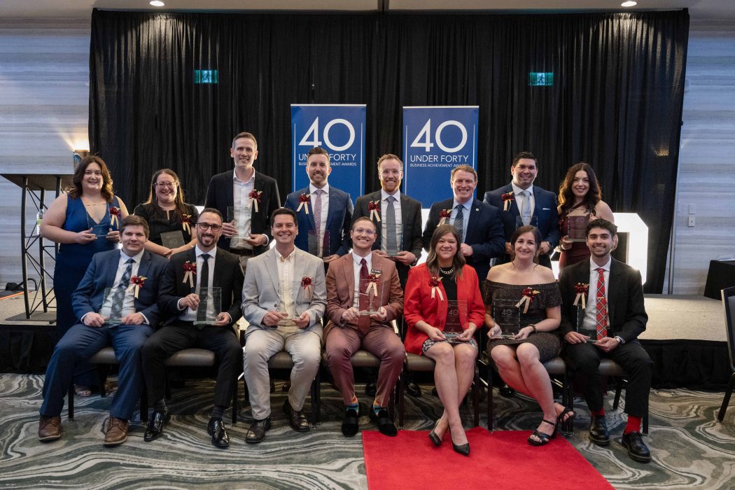 Two rows of people in business attire pose for a photo.