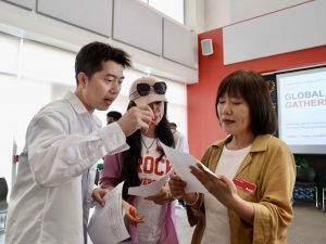 Three people have a conversation while looking at a piece of paper.