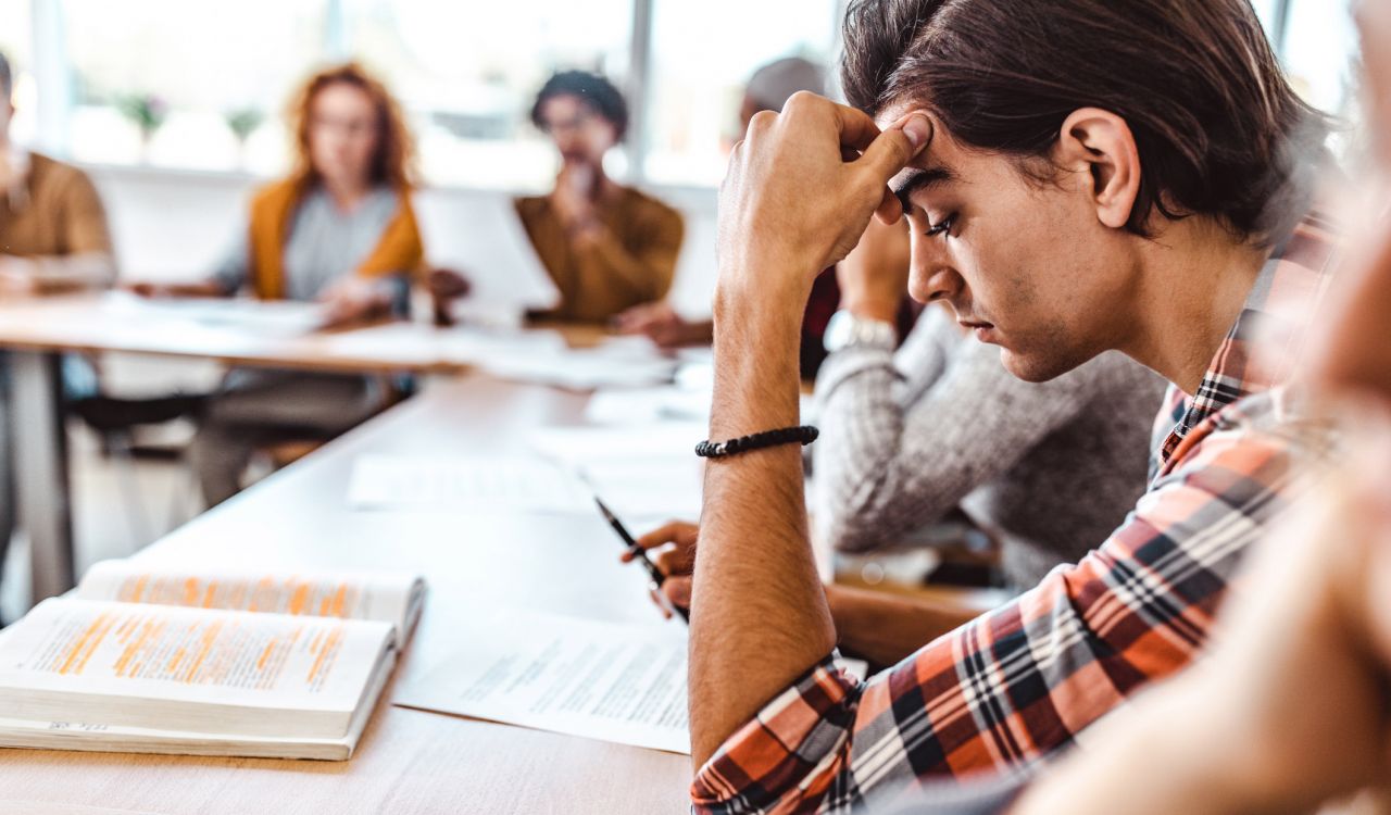 A university student stares at a notebook during class.