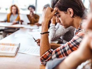 A university student stares at a notebook during class.