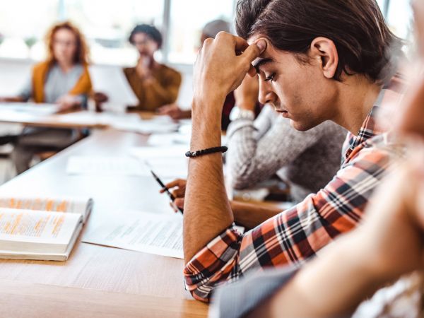 A university student stares at a notebook during class.