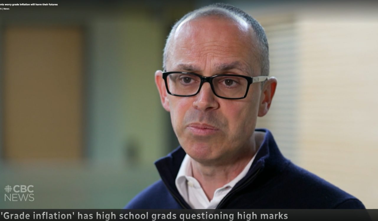 A man speaks to a camera, which is not visible, during a news interview.