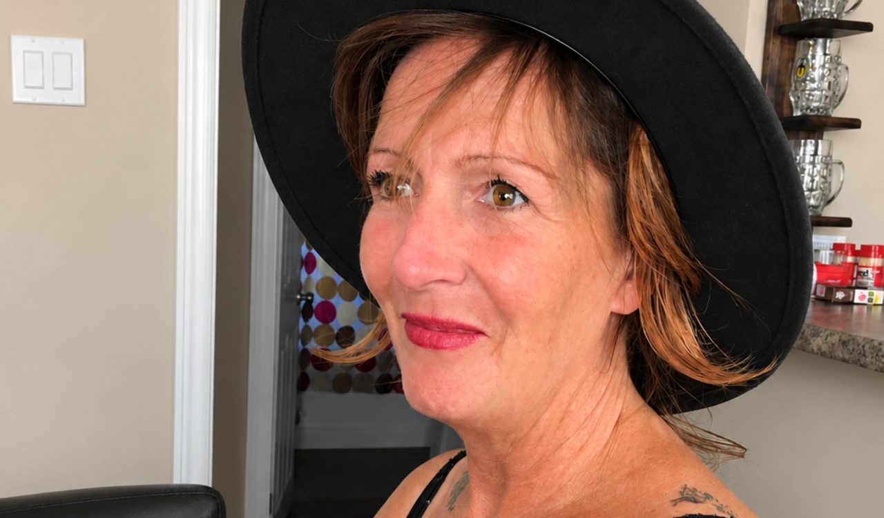 Christina Sewell smiles for a photo in a living room.