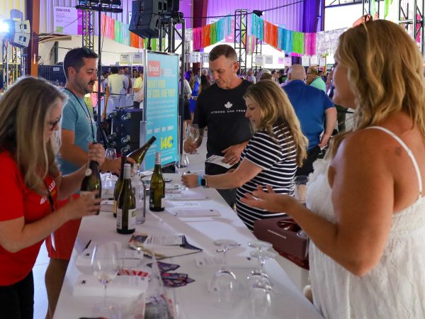 Two CCOVI experts stand behind a table pouring wine for event for International Cool Climate Chardonnay Celebration (i4C) event attendees.