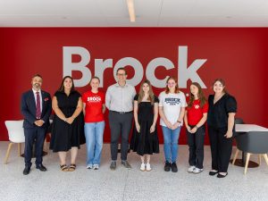 A group of Brock students stand in a line with MP Chris Bittle in the atrium of Brock’s main campus.