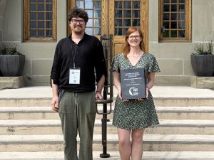 Robert Blom and Emily Krushelnycky stand side by side smiling outside of the University of Winnipeg.