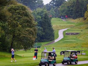 People play golf on a rainy day.