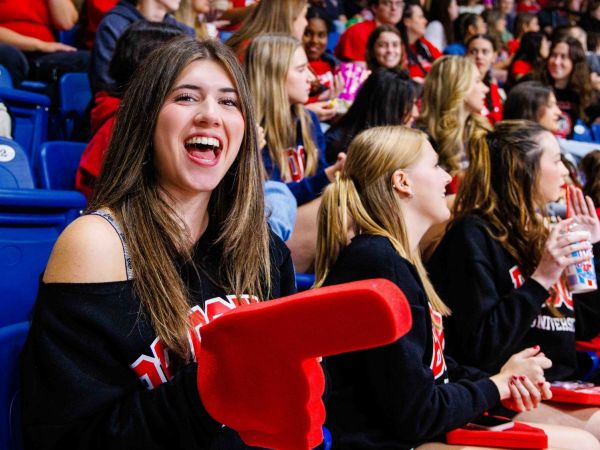 A crowd cheers on a university ice hockey game.