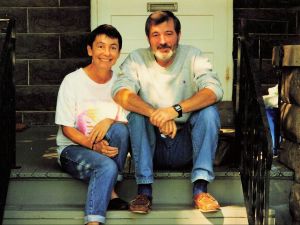 A man and a woman sit on porch stairs.