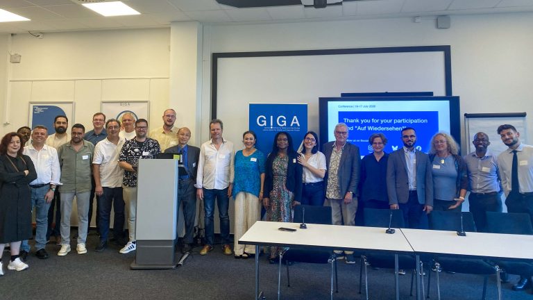 A large group of researchers stand together at the University of Hamburg.