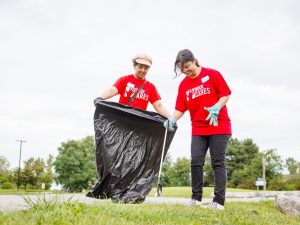 Two students pick up garbage at a volunteering event.