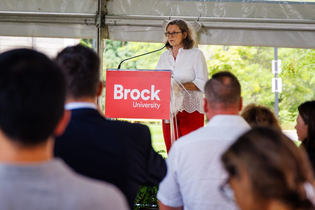 A woman speaks from a podium during an event.