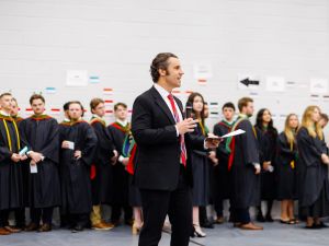 A speaker addresses a group of graduands gathered during a convocation ceremony.