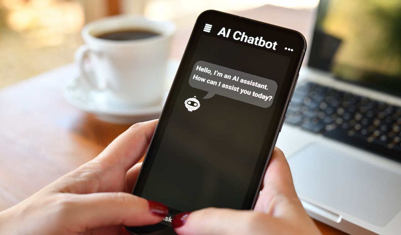 A close-up view of hands holding a phone displaying an AI chatbot.
