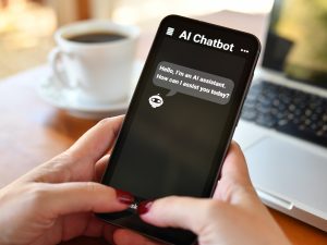 A close-up view of hands holding a phone displaying an AI chatbot.