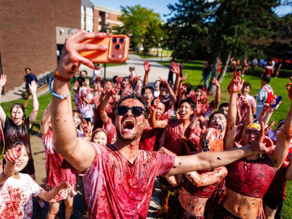 A university student takes a selfie with a crowd at Brock's annual grape stomp.