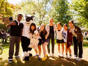 A group of student pose with Brock University's mascot, Boomer the Badger.