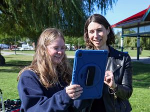 Hannah Sharp and Julia Baird look at a digital tablet