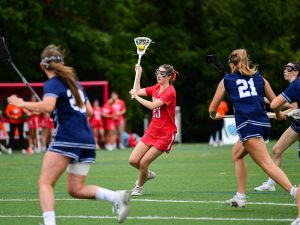 Women play in a lacrosse match.