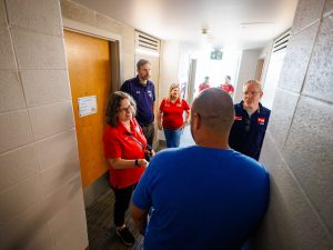 A group of people chat in the hallway of a Brock University residence building.