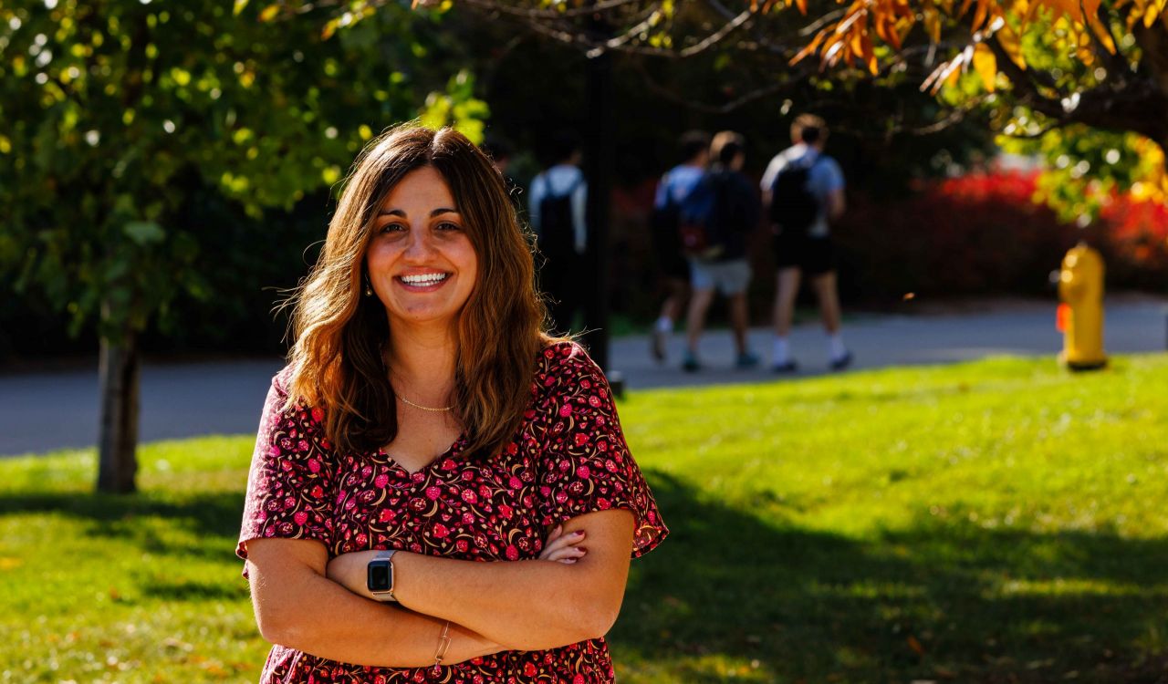 Natalie Spadafora stands outside in a green space.