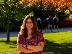 Natalie Spadafora stands outside in a green space.