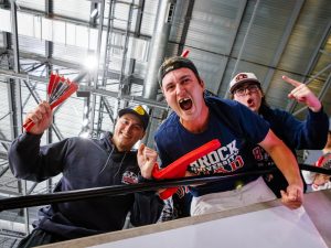 A group of men in Brock Badgers shirts scream with excitement.