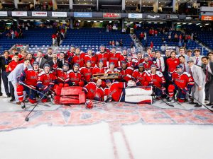 The Brock Badgers men's hockey team poses on the ice with a trophy.