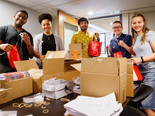 Five Brock University students prepare Welcome Wagon packages and materials for incoming students.
