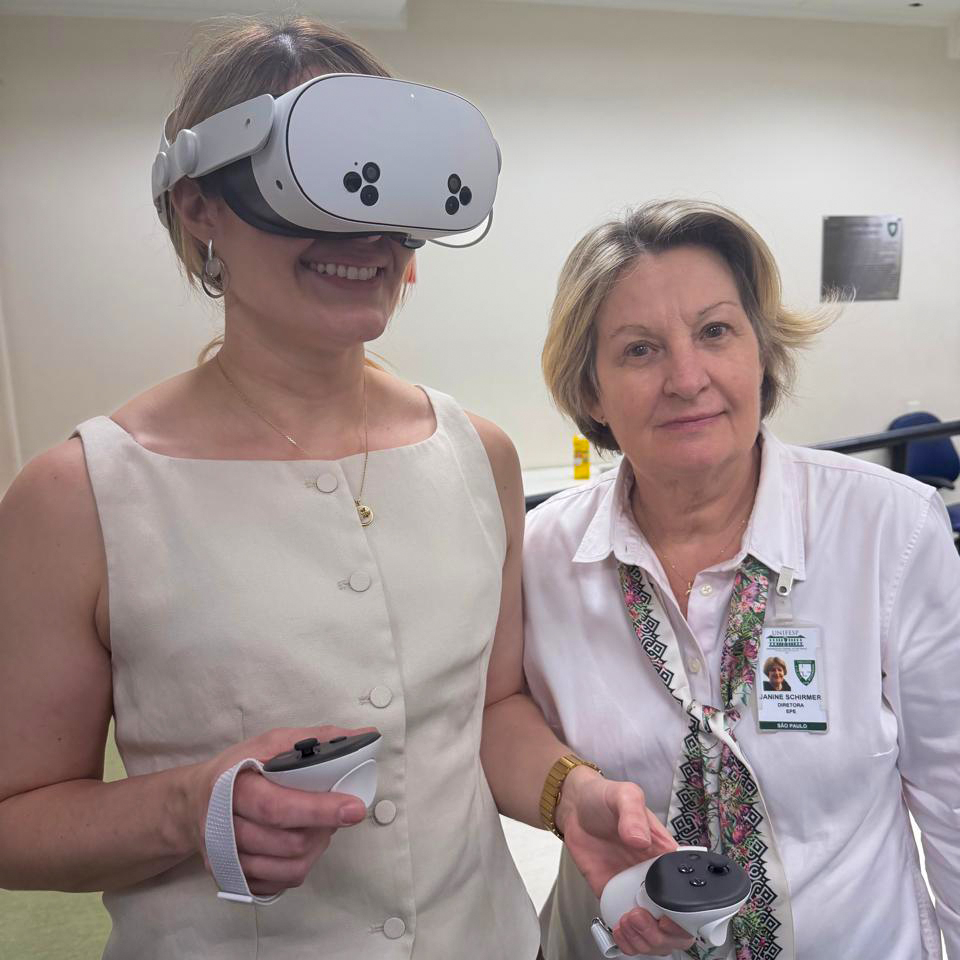 A woman wearing virtual reality headset beside another woman.