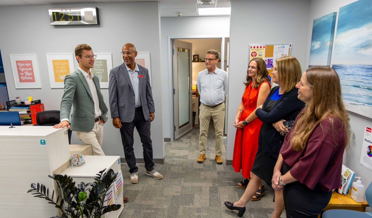 A group tours a counselling and wellness space at Brock University's Student Wellness and Accessibility Centre. Sam Oosterhoff speaks with Brock representatives Brad Clarke, Bill Helmeczi, Kerri Nagy, Alexandra Lawson and Renata Faber while discussing student support services.