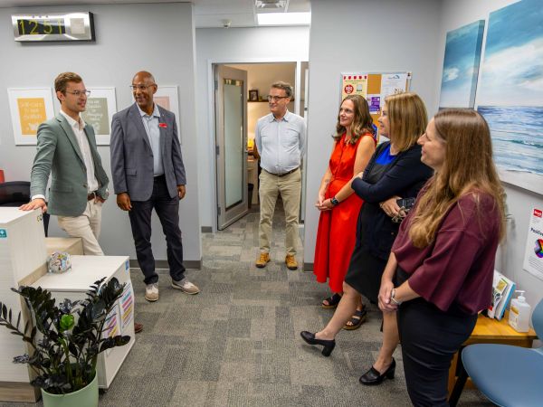 A group tours a counselling and wellness space at Brock University's Student Wellness and Accessibility Centre. Sam Oosterhoff speaks with Brock representatives Brad Clarke, Bill Helmeczi, Kerri Nagy, Alexandra Lawson and Renata Faber while discussing student support services.