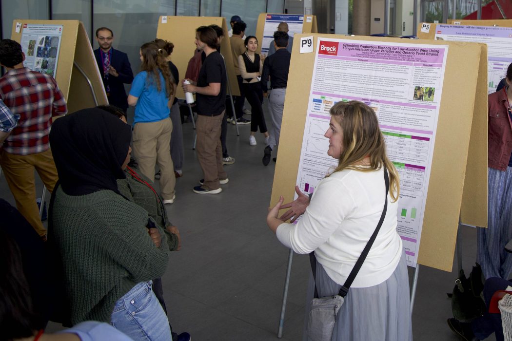 There is a group of university students sharing their research with attendees at a conference.