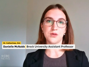 Screenshot of a CBC News television newscast featuring an interview with a female guest wearing glasses participating remotely via Zoom.