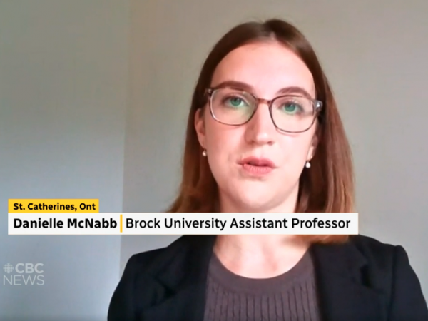 Screenshot of a CBC News television newscast featuring an interview with a female guest wearing glasses participating remotely via Zoom.