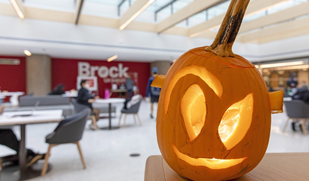 A jack-o-lantern in a sunny atrium.