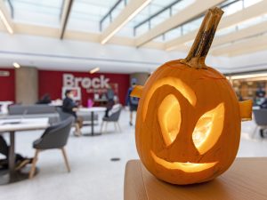 A jack-o-lantern in a sunny atrium.