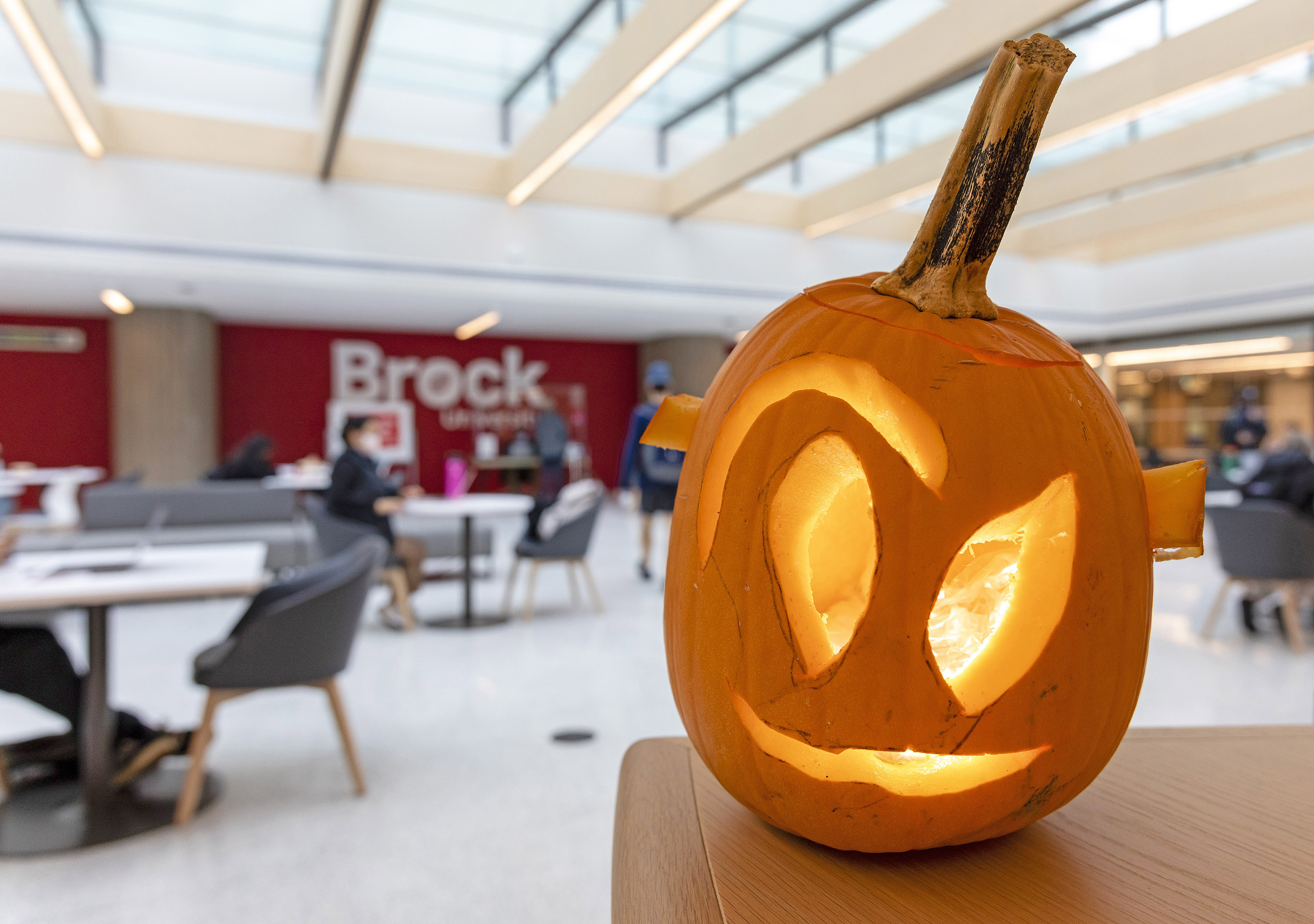 A jack-o-lantern in a sunny atrium.
