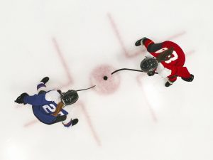 Two women play ice hockey.