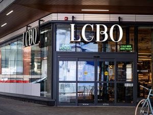 The exterior of an LCBO store with large signage overtop of glass doors.