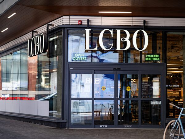 The exterior of an LCBO store with large signage overtop of glass doors.