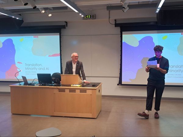 Nicholas Hauck and Michael Cronin stand at the front of a lecture hall at Brock University addressing a room.