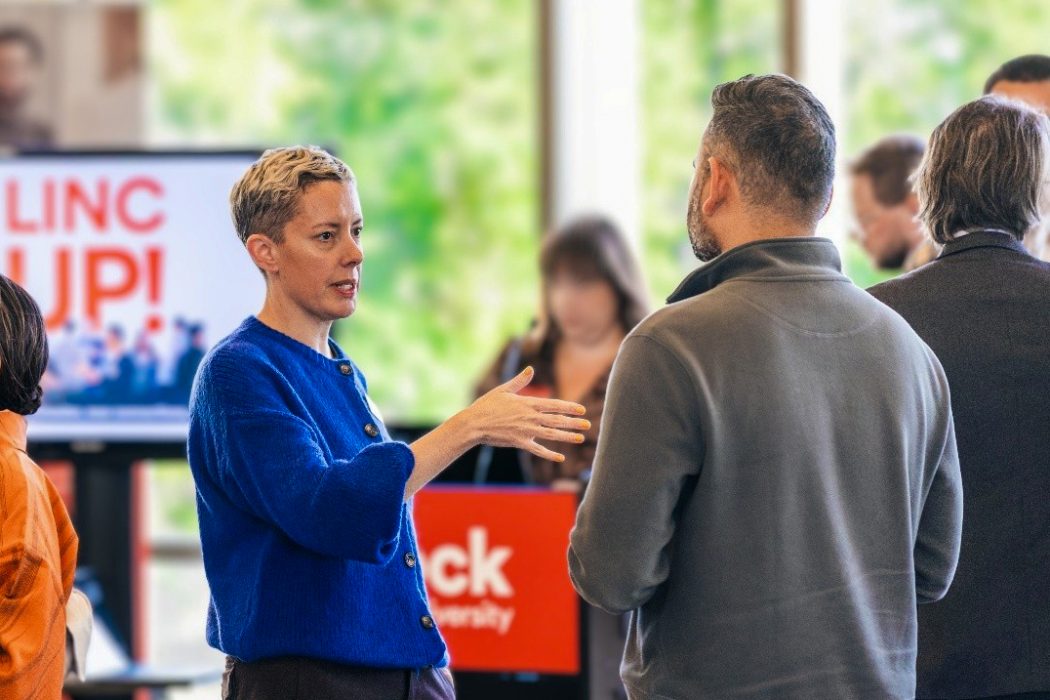 People chat with each other at a networking event.