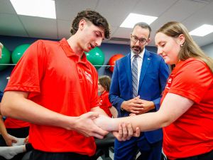 First-year MAT students Zach Perna and Olivia Nero demonstrate musculoskeletal assessment techniques with Minister Nolan Quinn inside Brock's campus anatomy lab.
