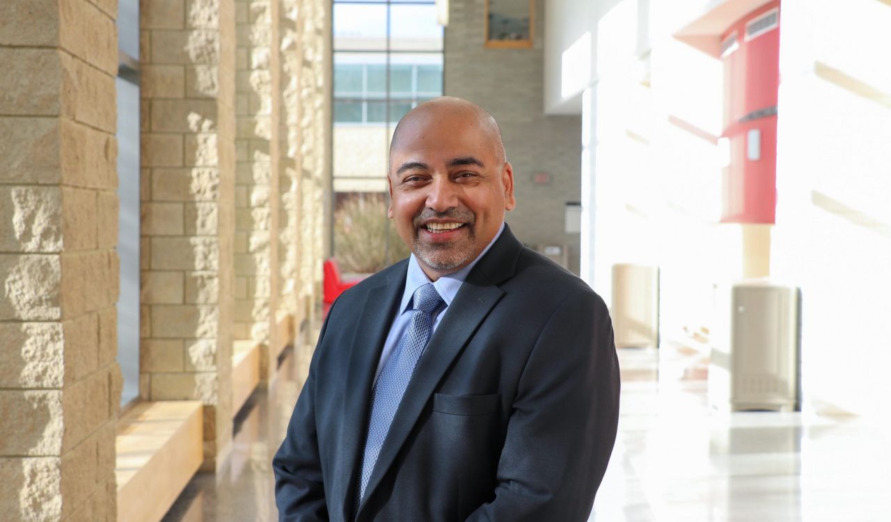 Rahul Kumar stands in a brightly lit hallway at Brock University.
