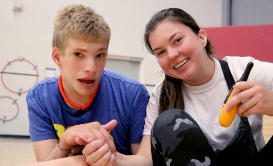 Participant and graduate student volunteer smiling and holding hands.