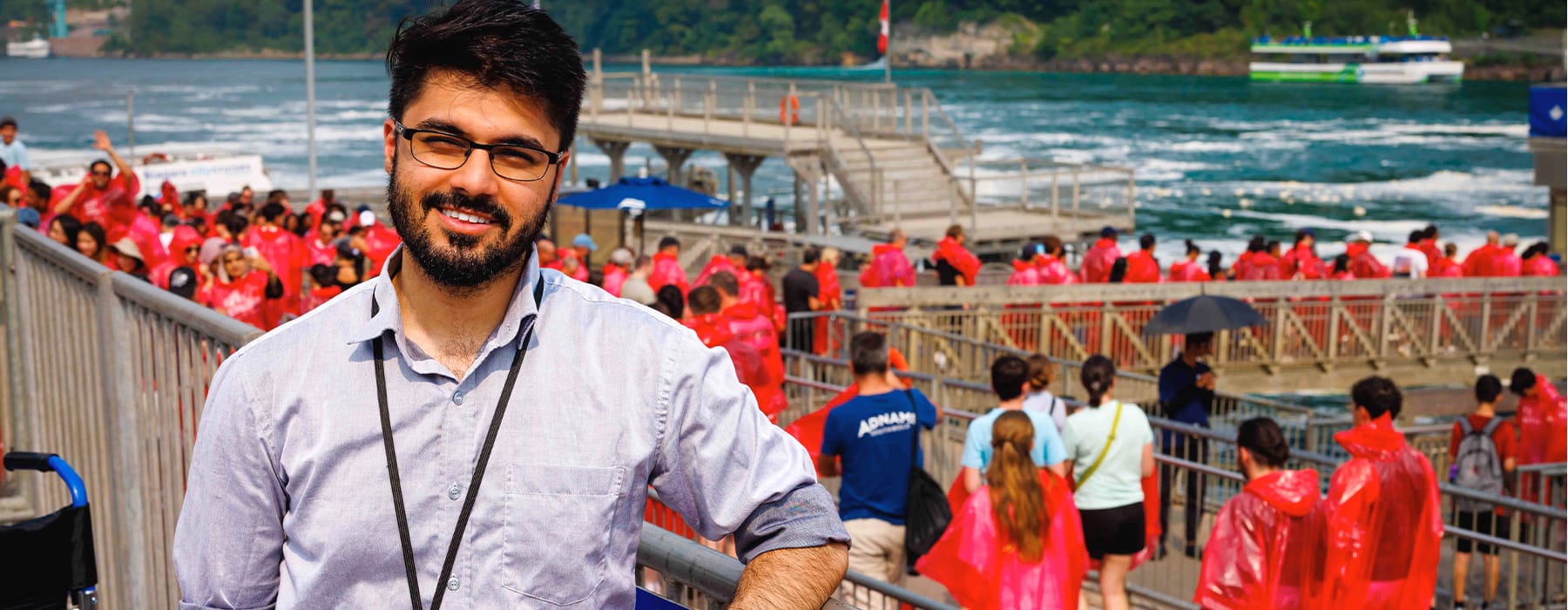 Experiential educator infront of a group of people in red rain gear going on a boat tour