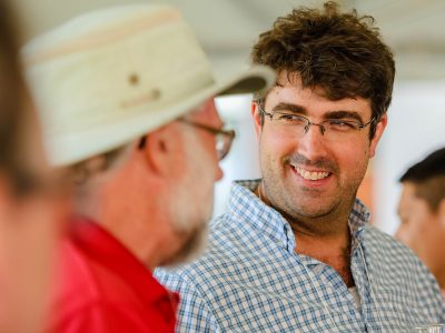 2 men one smiling at a wine event
